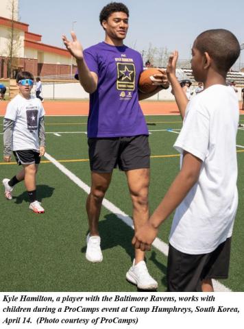 NFL player Kyle Hamilton with two ProCamps participants at Camp Humphreys, South Korea